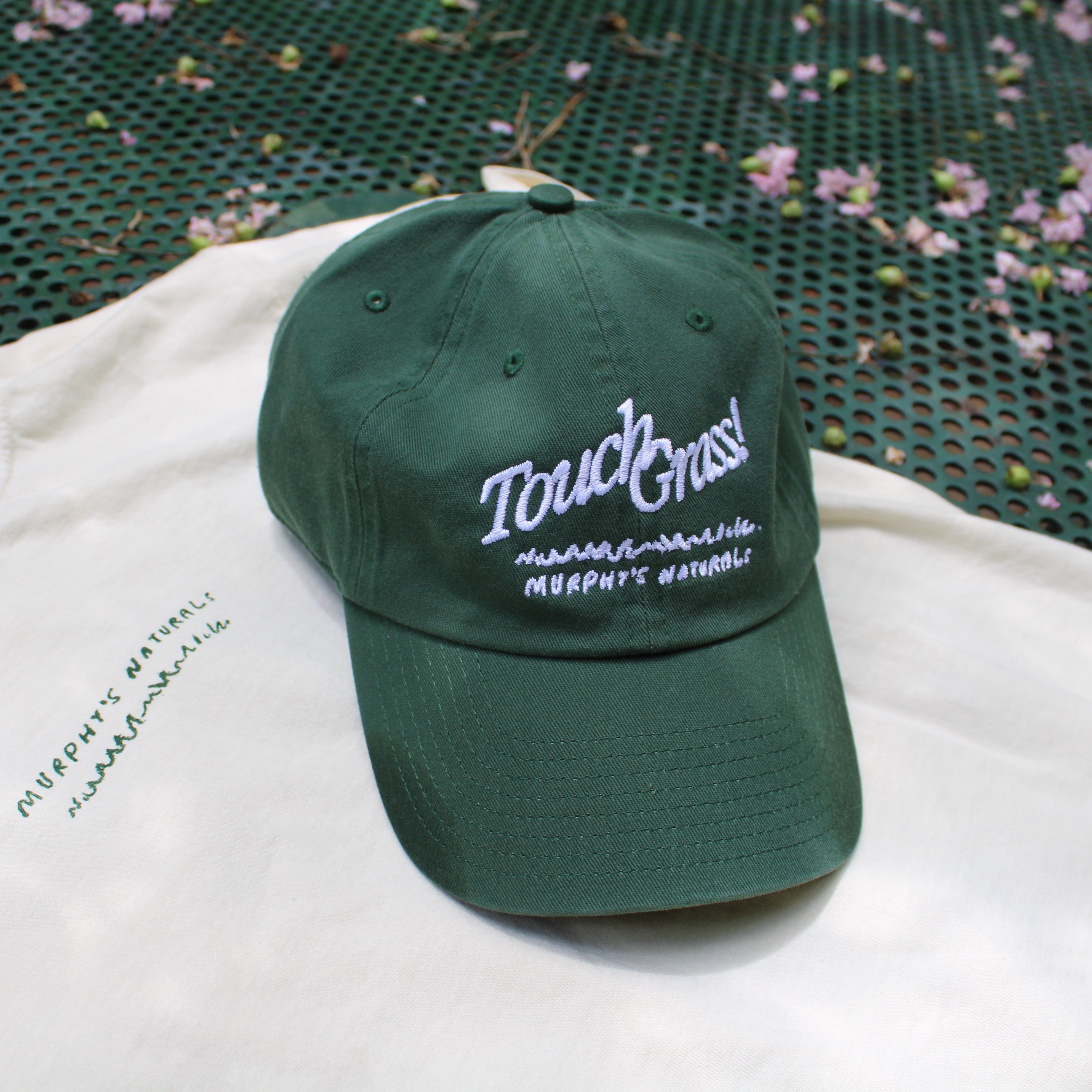 Touch Grass hat sitting on the accompanying t shirt.