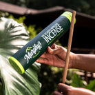 A person holding a mosquito repellent incense stick with a a bright green and dark green label.