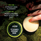 Mosquito Repellent Balm on a mossy log with a persons finger picking up product