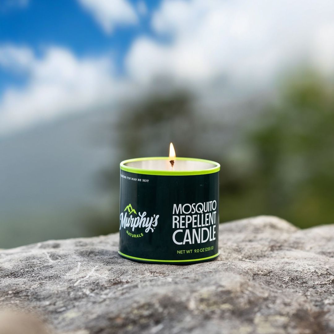 Murphy's Naturals mosquito repellent candle on a rock with a blurred natural background