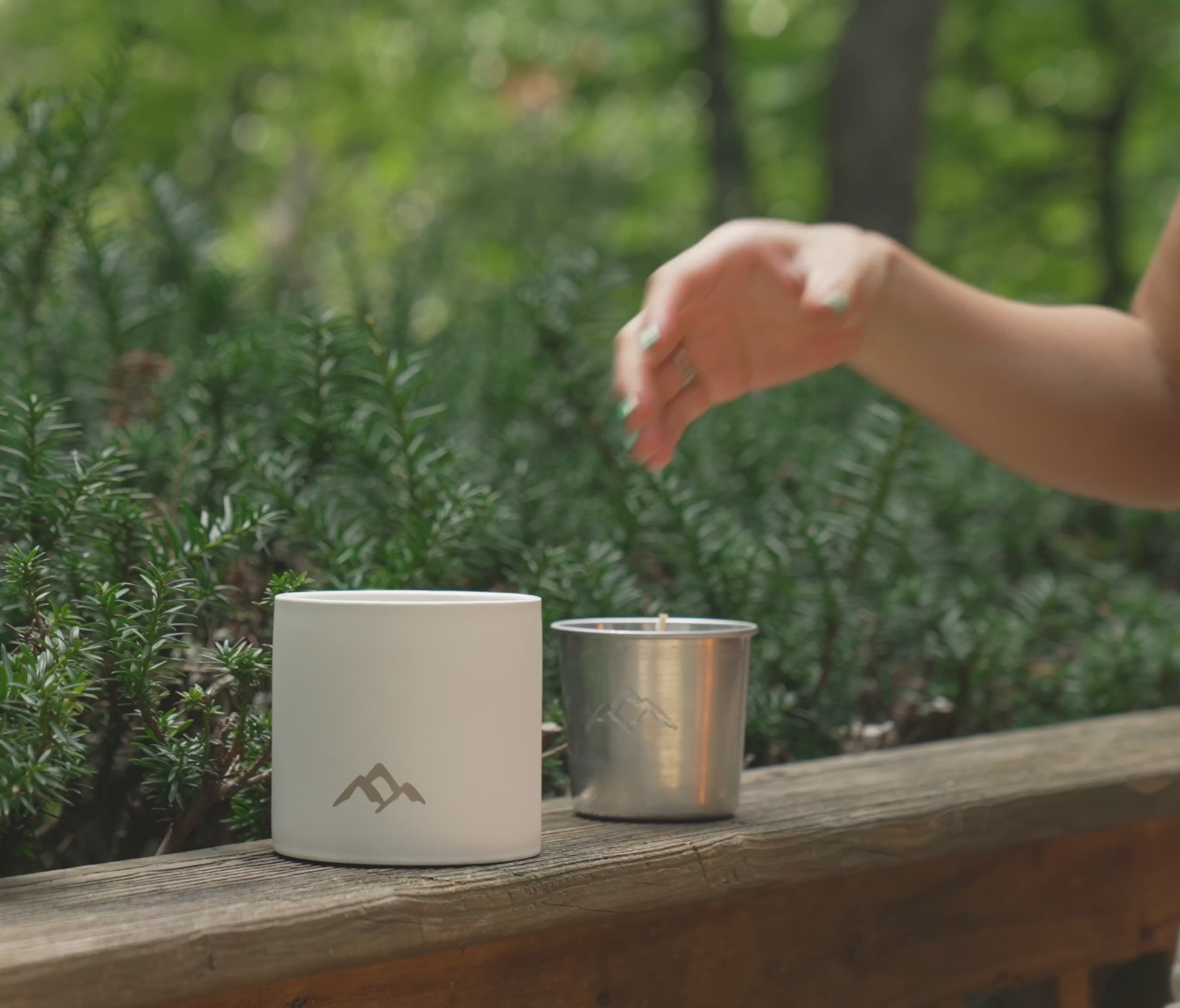 woman inserting candle refill into ceramic vessel and lighting one done