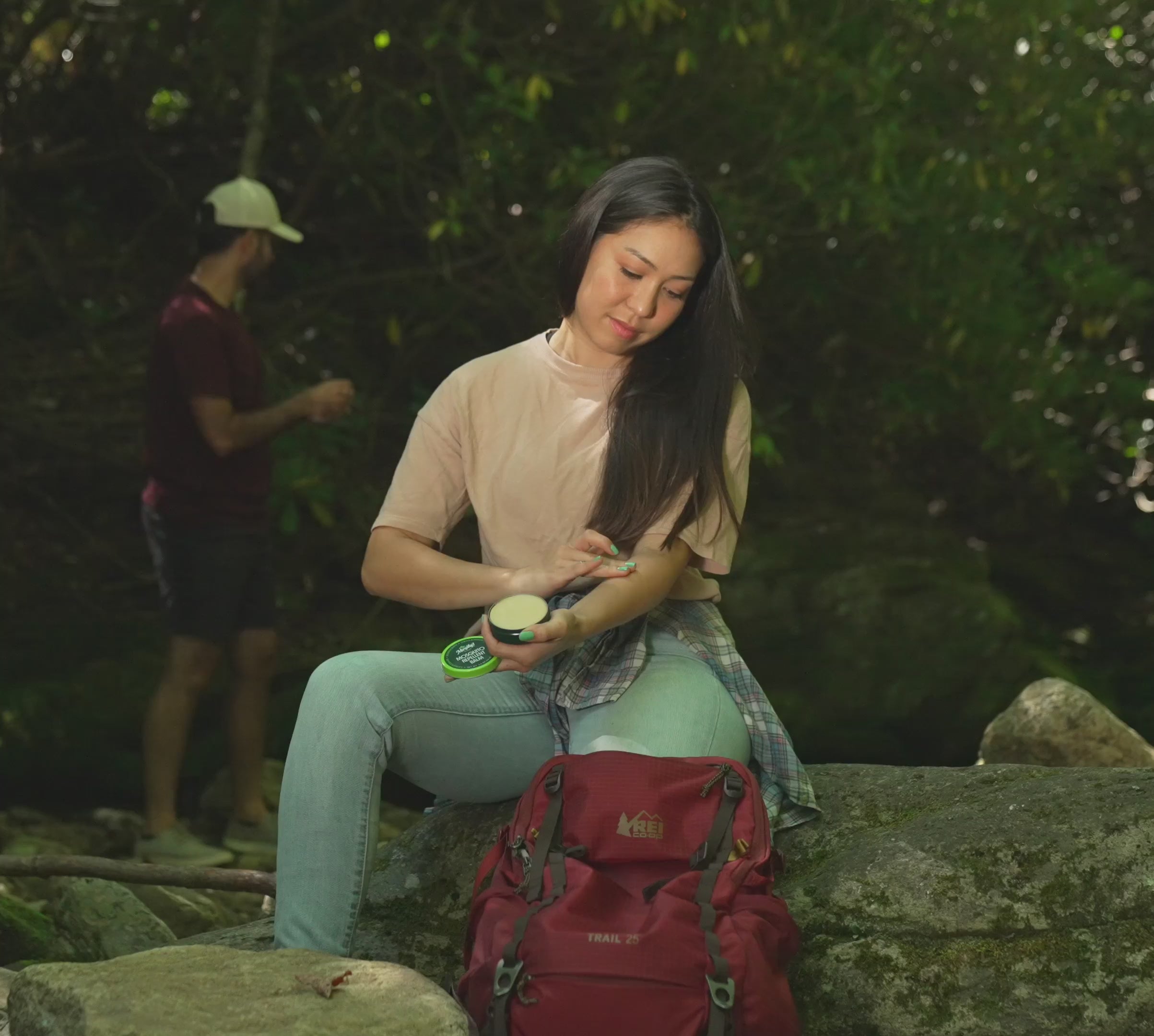 woman applying mosquito repellent balm to arm